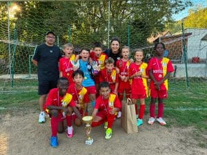 Jeunes joueurs posant avec leur coupe et leurs sachets cadeaux