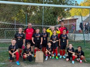 Jeunes joueurs en maillot noir et rouge avec leurs médailles